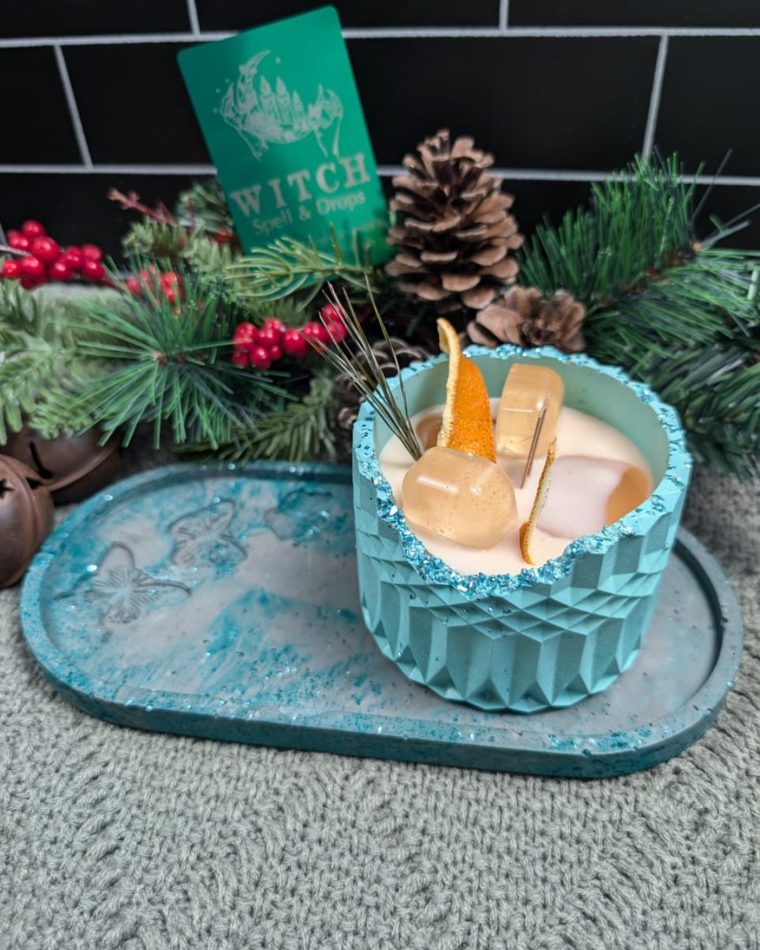 A candle With Ice cube wax, simulating a drink on concrete jar. On top of a concrete plate