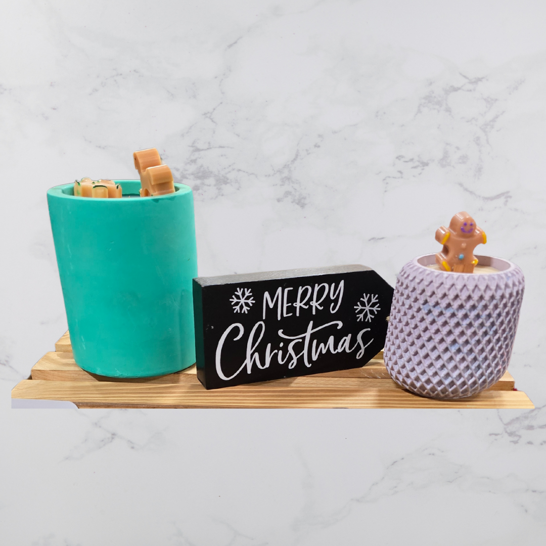 A Candle on concrete jar with gingerbread man made of wax